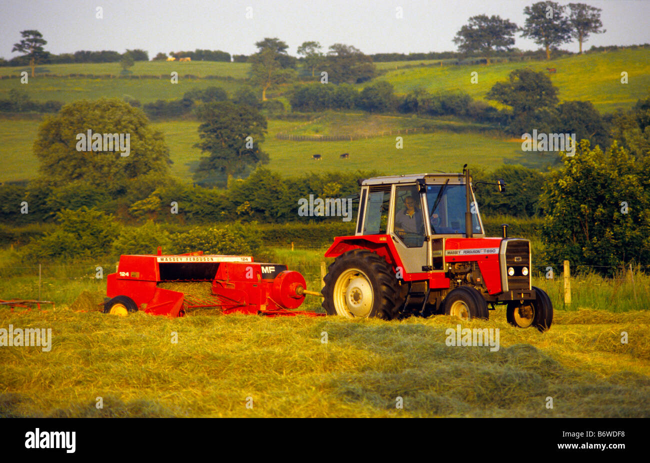 Farmer with old Massey Ferguson 690 Tractor and 124 Hay Baler, Wiltshire, UK.