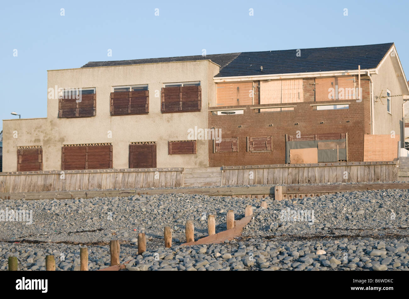 Two seaside houses in Borth west wales boarded up and shuttered for the