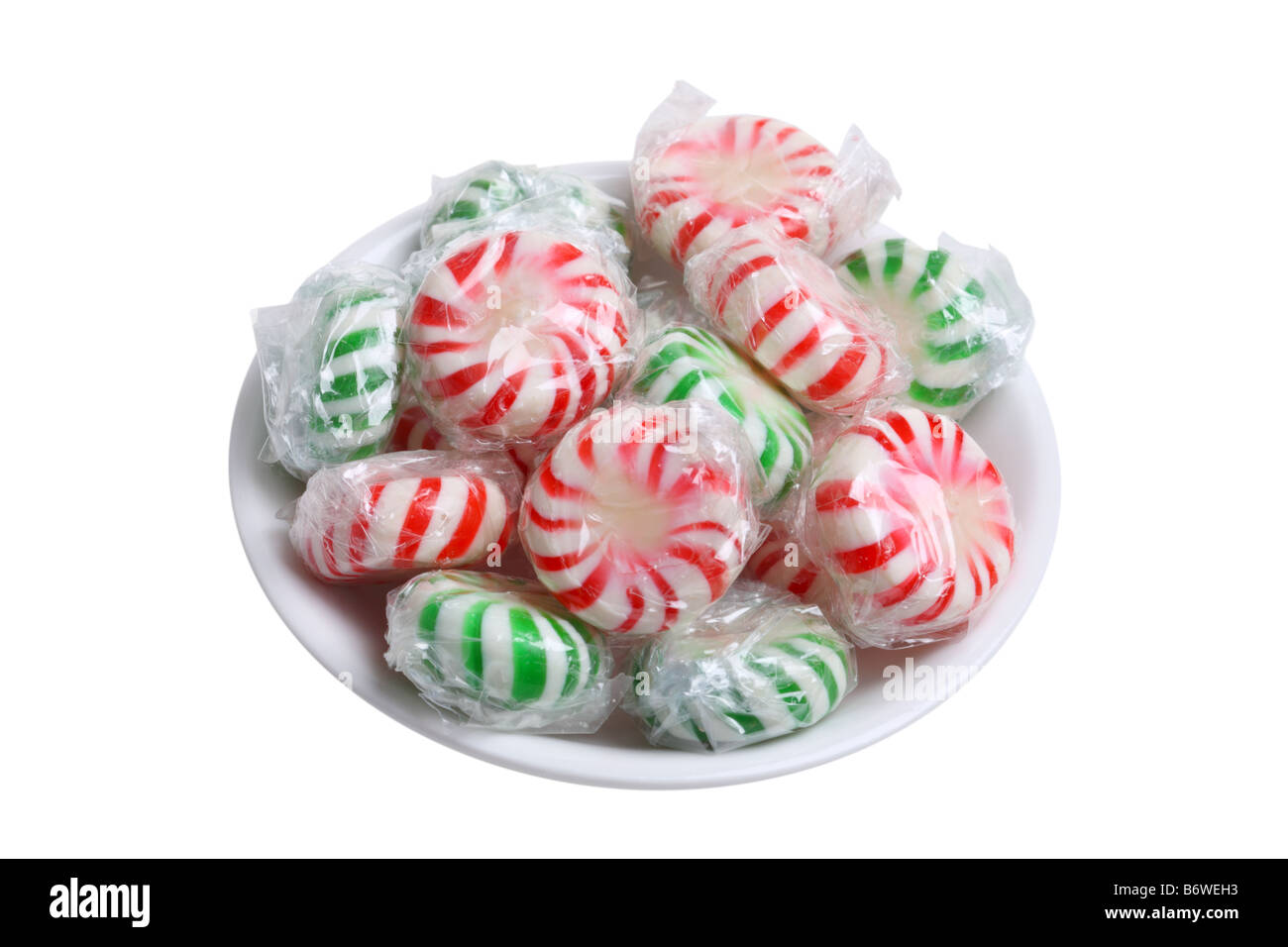 Small bowl of peppermint candies cut out isolated on white background Stock Photo