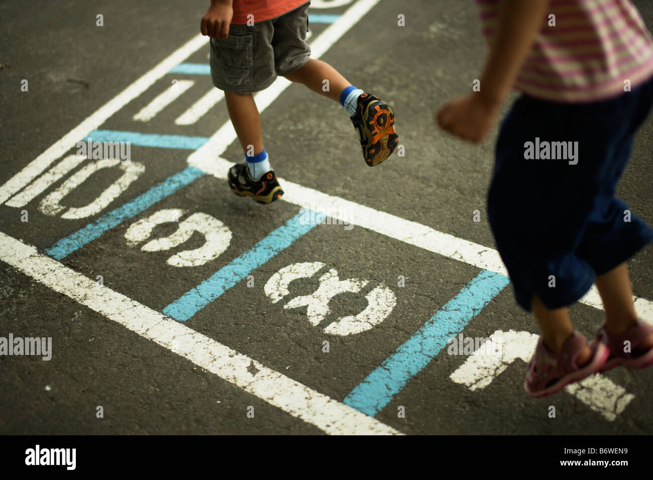 Children play hopscotch in a school playground Stock Photo