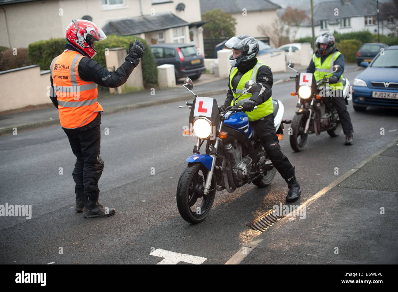 Driving instructor giving lessons to two men on motorbikes Aberystwyth Wales UK Stock Photo