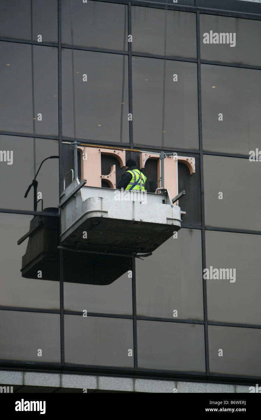 A workman repairing the FT sign on the Financial Times building in London Stock Photo