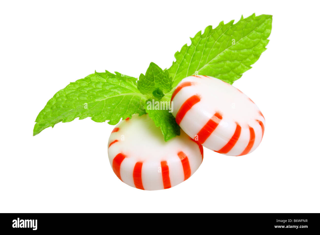 Peppermint candies and mint leaves cut out isolated on white background Stock Photo
