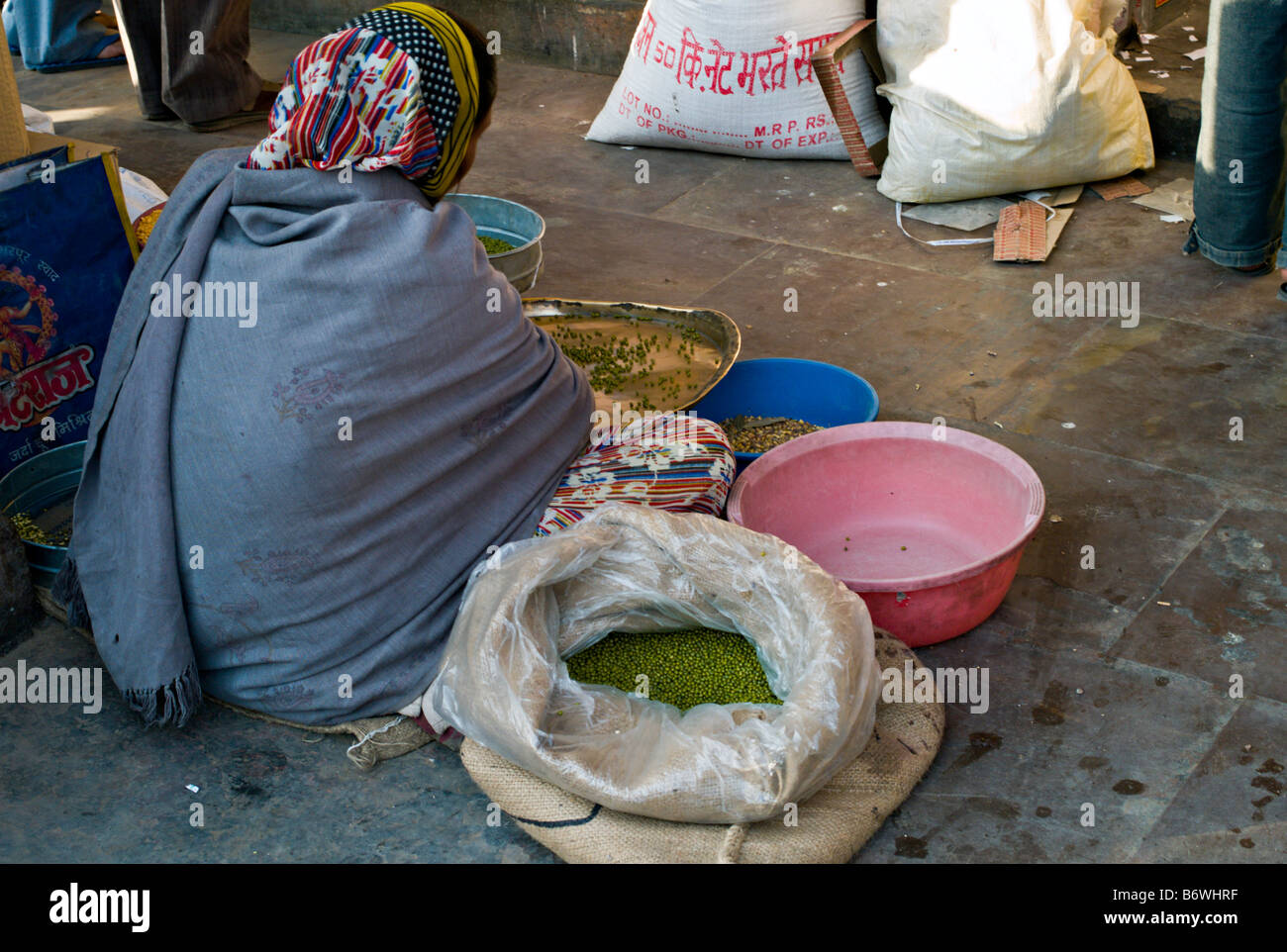 INDIA JAIPUR RAJASTHAN Indian woman sitting on the sidewalk sorting