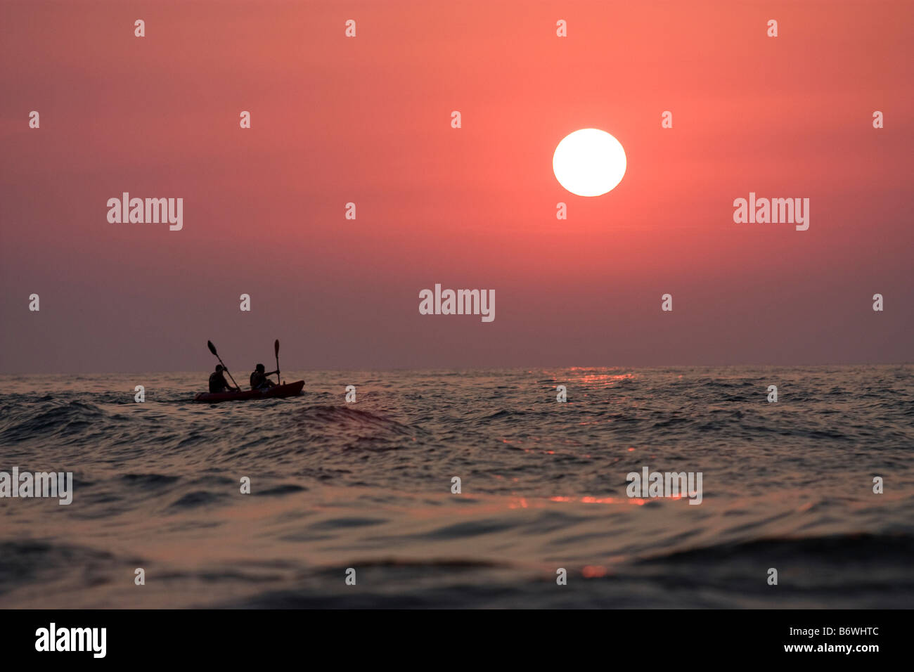 Tandem kayakers paddling on Lake Michigan near sunset time Stock Photo