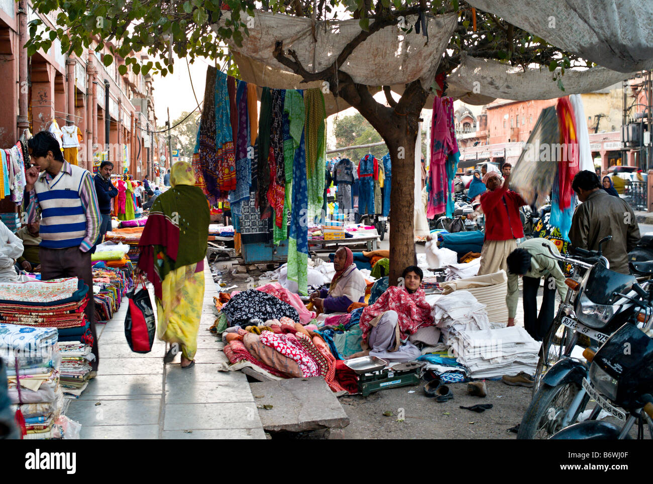 INDIA JAIPUR RAJASTHAN Vendors and touts sell colorful fabrics and