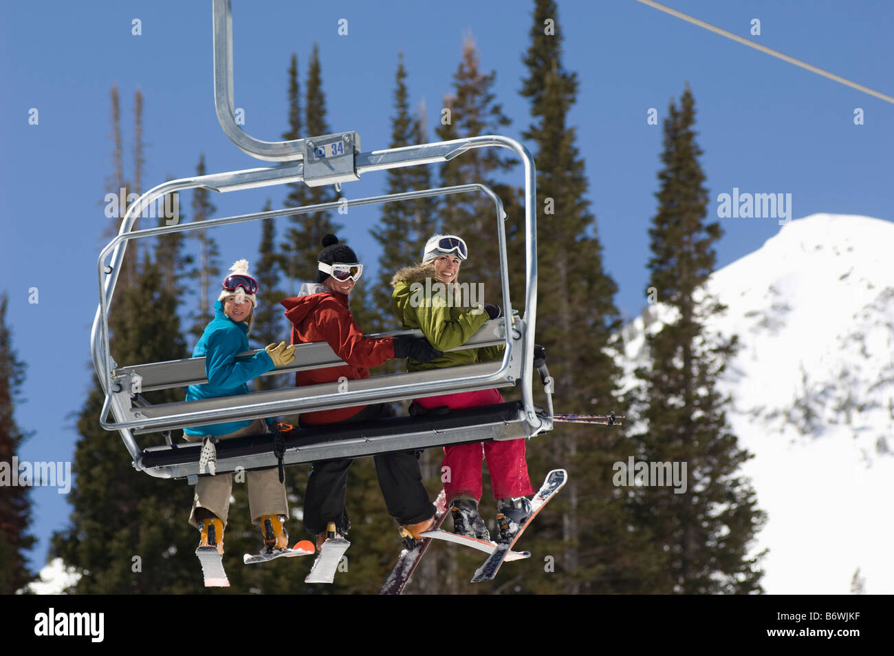 Three Skiers on Chair Lift Stock Photo - Alamy