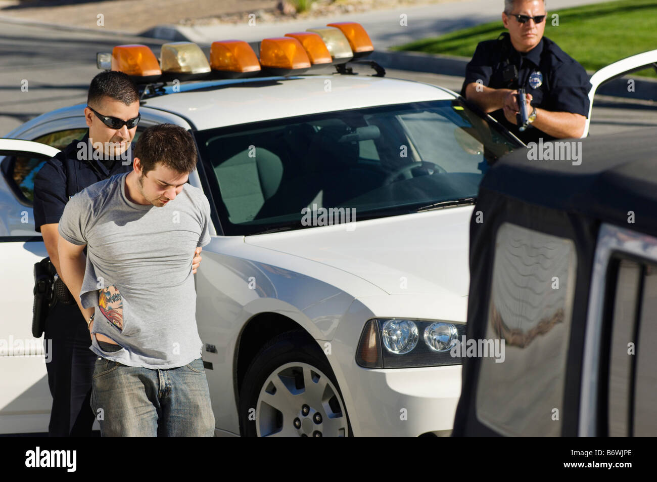 Police Officer Arresting Young Man Stock Photo - Alamy