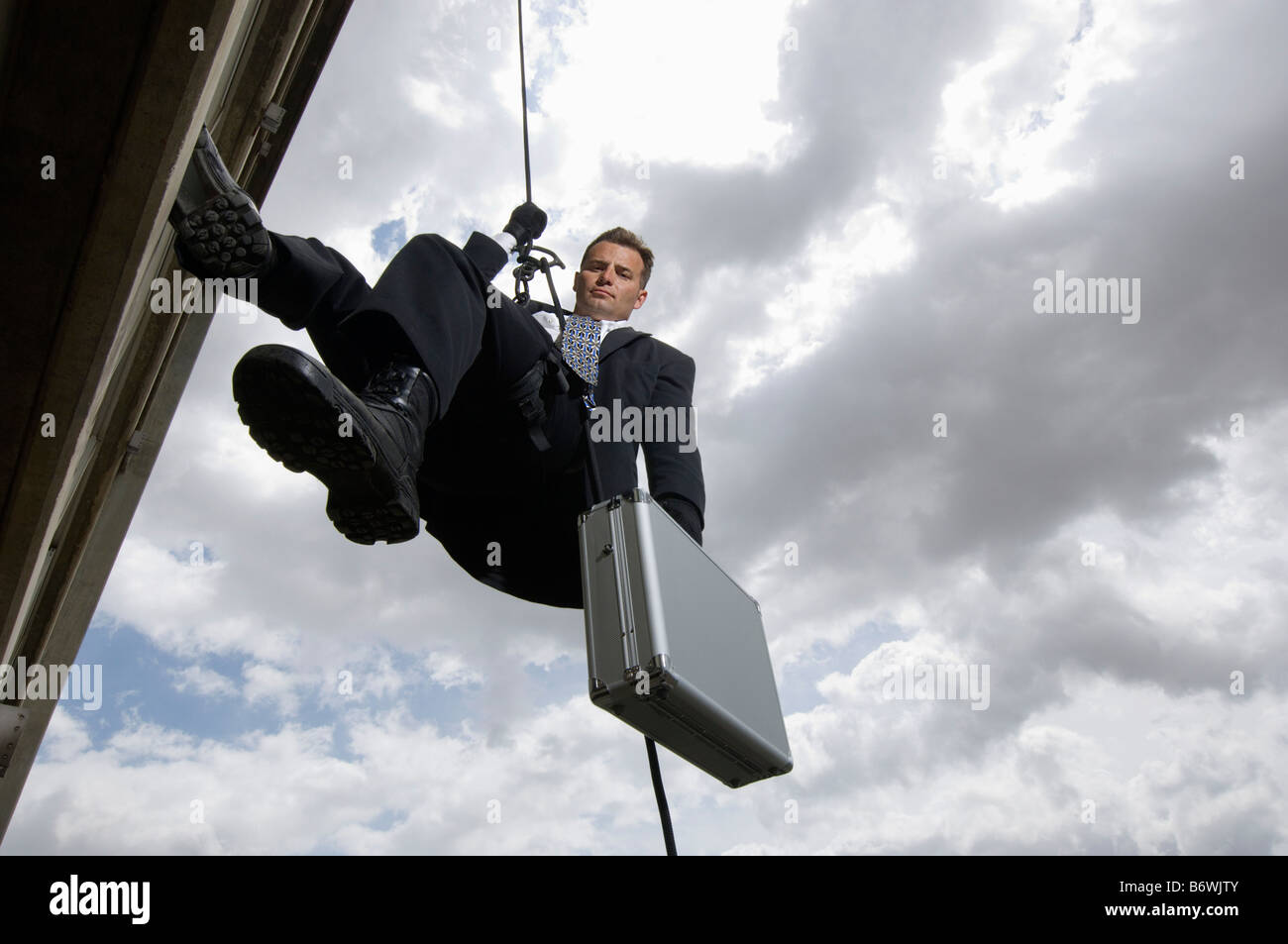 Spy Rappelling with Suitcase Stock Photo - Alamy