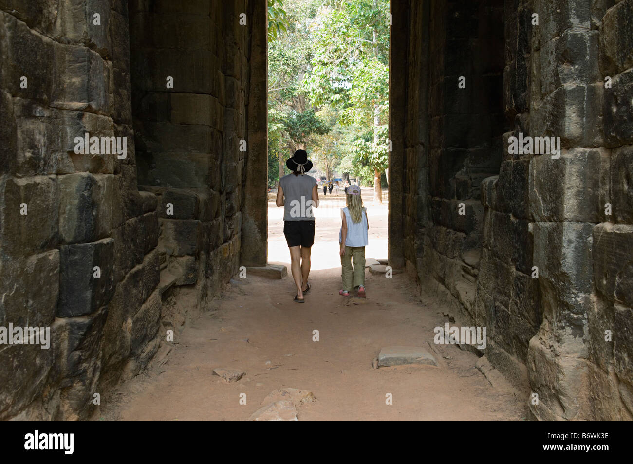 Woman and Girl Walking Through Passage in Ancient Building Stock Photo