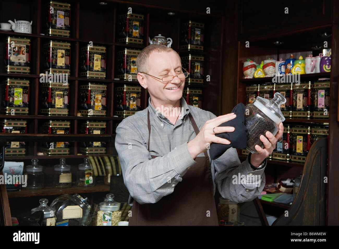 Tea Shop Owner Dusting Jar of Tea Stock Photo Alamy