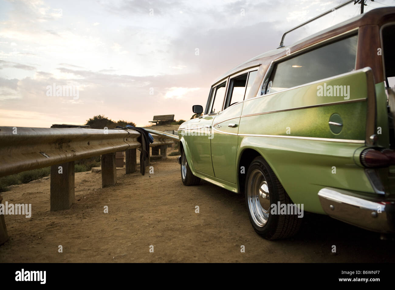 surfboards sit next to vintage car at beach Stock Photo