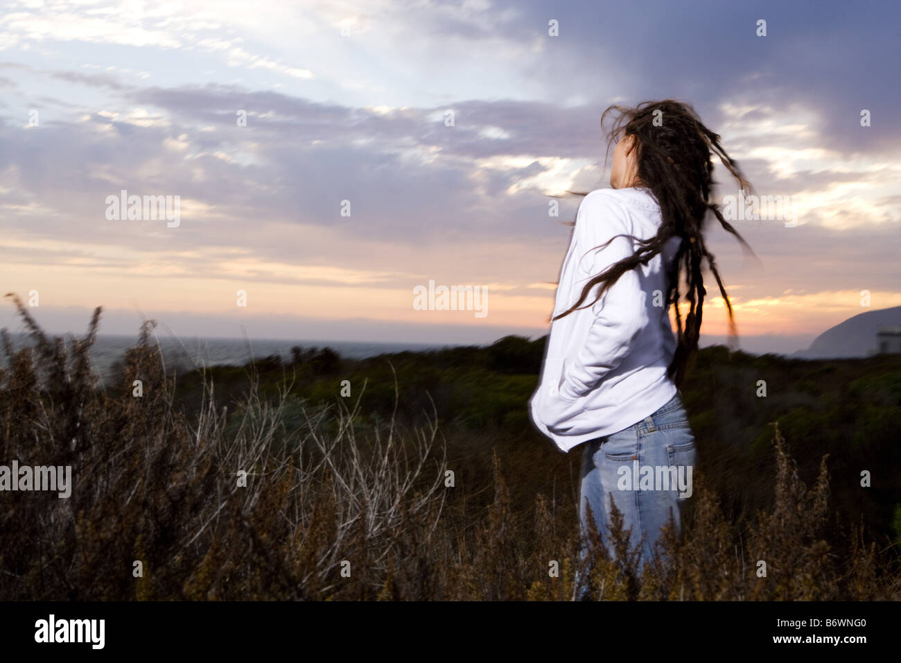 woman at beach at sunset throws her head back Stock Photo Alamy
