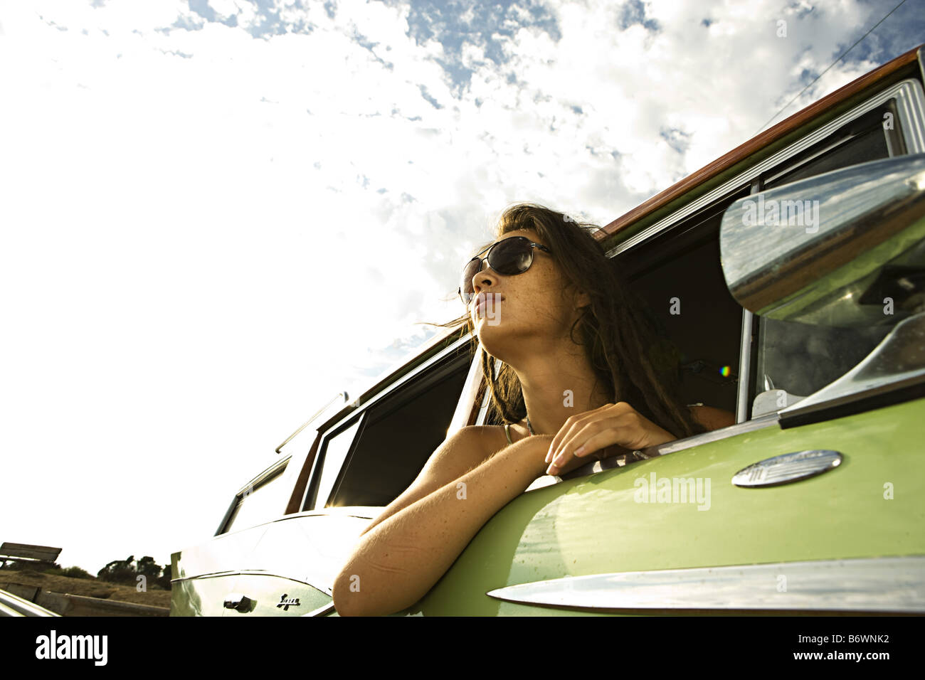 girl leans out of window in vintage car at beach Stock Photo