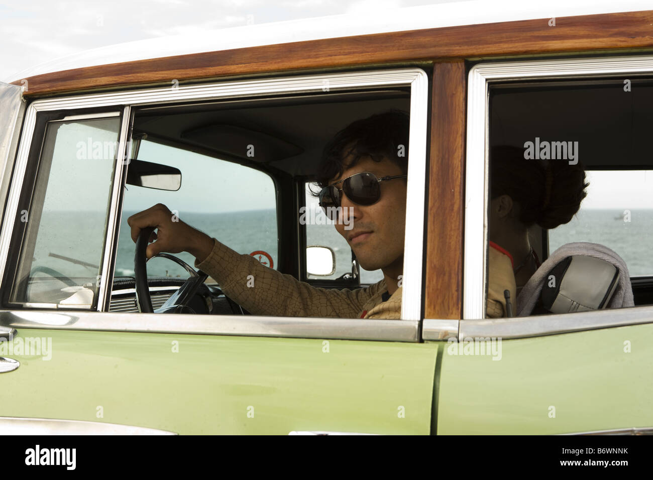 man looks out of window of vintage car in glasses Stock Photo