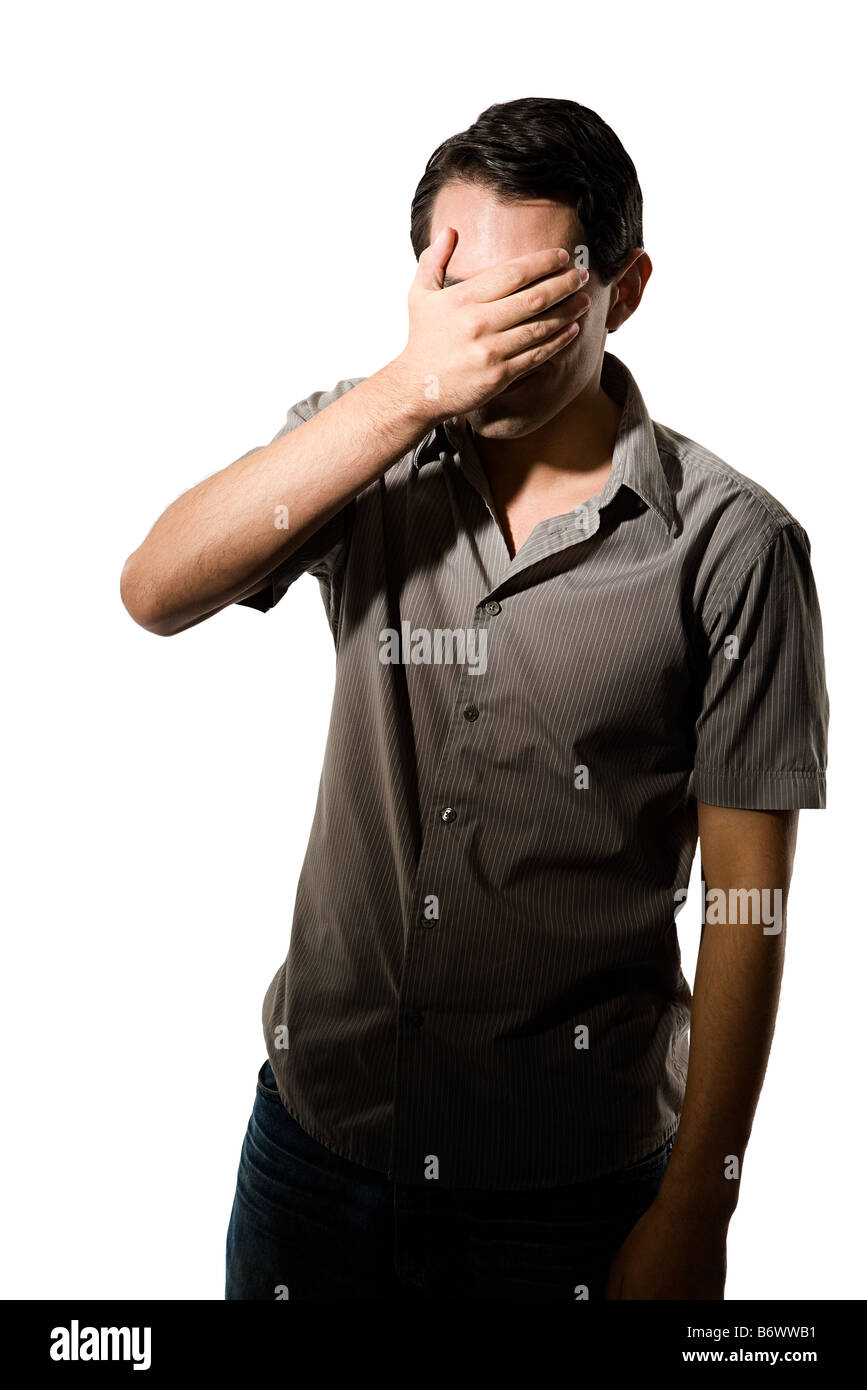 Young man covering his eyes Stock Photo Alamy