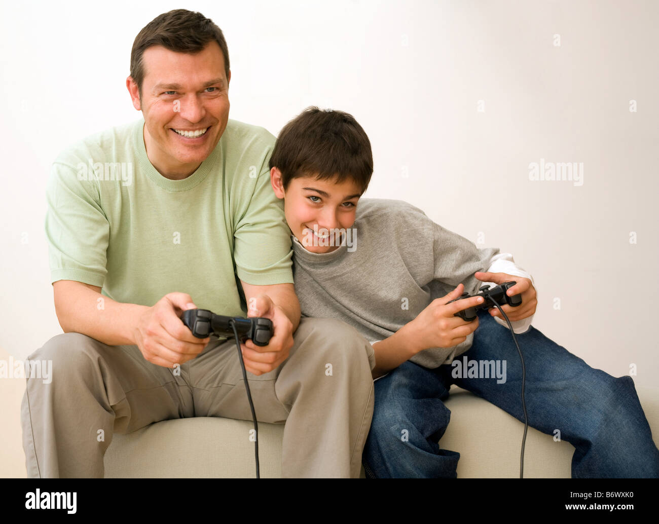 Папа играет с сыном. Отец и сын играют в Видеоигры. Папа и сын играют в приставку. Папа с сыном играют в плейстейшен.