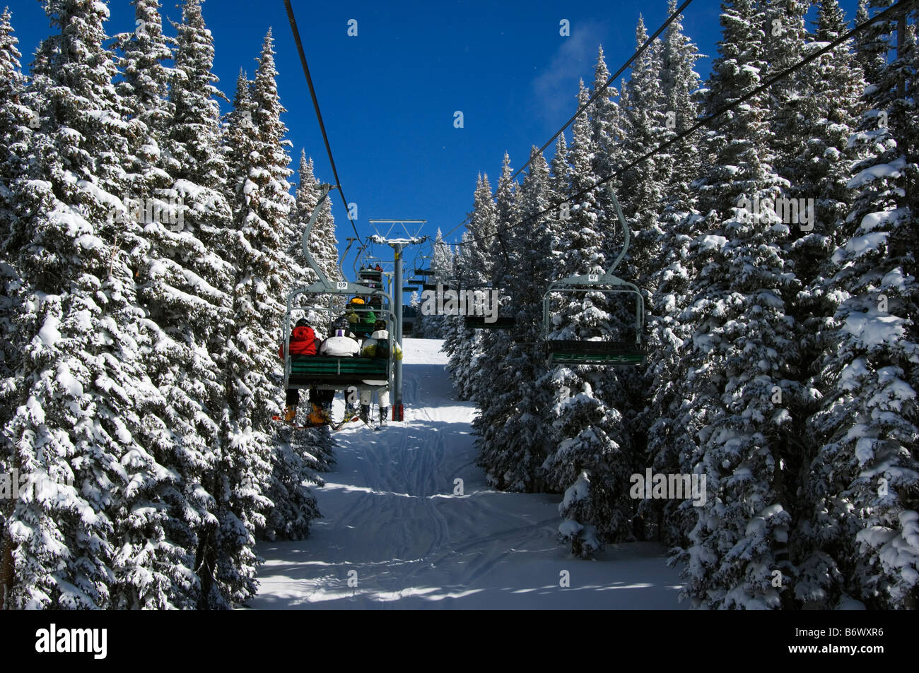 USA, Colorado, Vail Ski Resort. Skiers being carried on a chair lift in Vail back bowls Stock