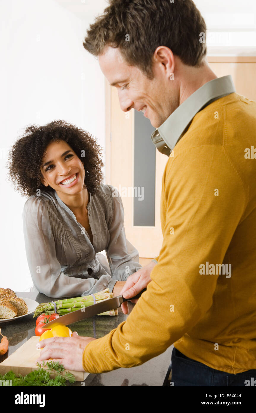 A couple preparing food in a kitchen Stock Photo