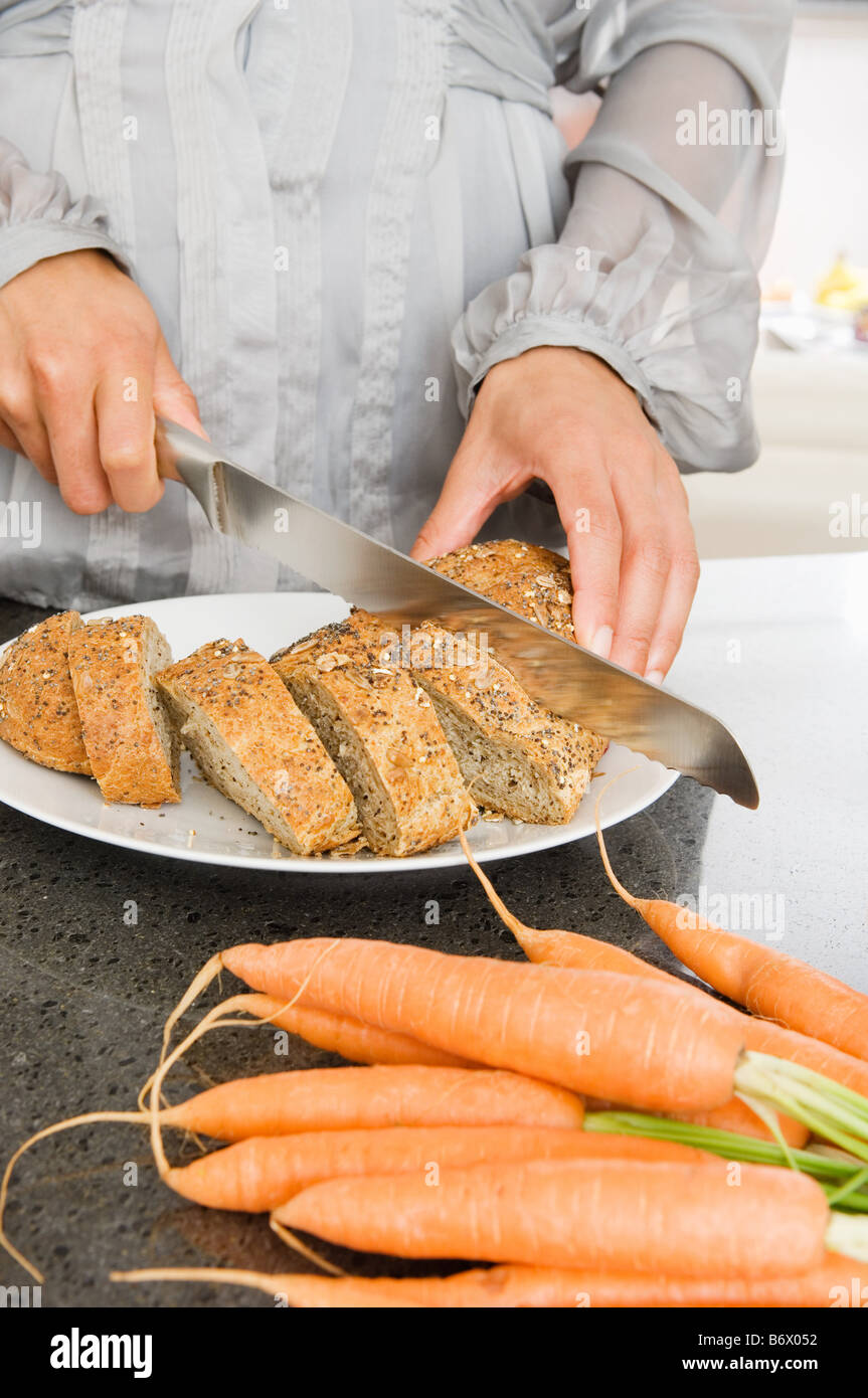 A woman slicing bread Stock Photo