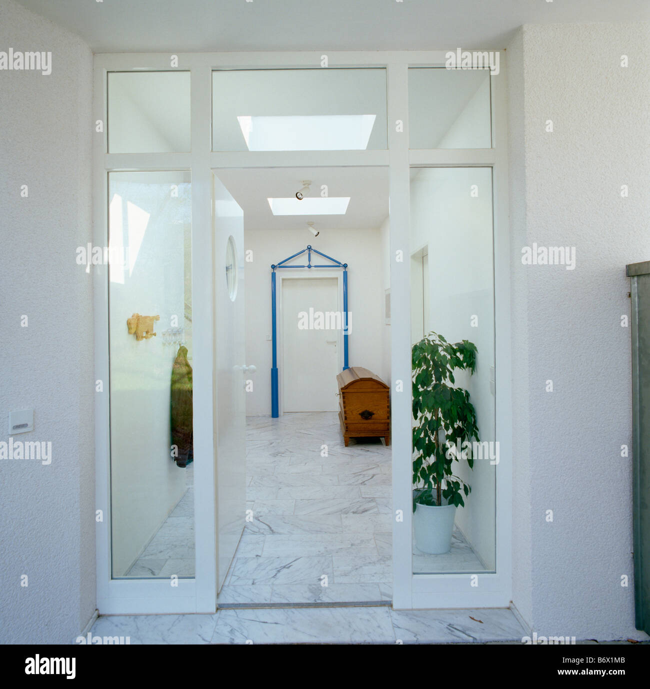 Glass Doors To Modern White Hall With Marble Flooring And Tall