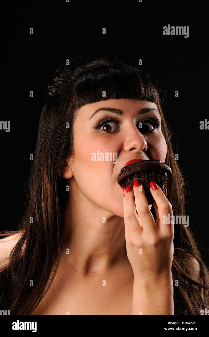 Pretty girl eating a chocolate muffin Stock Photo