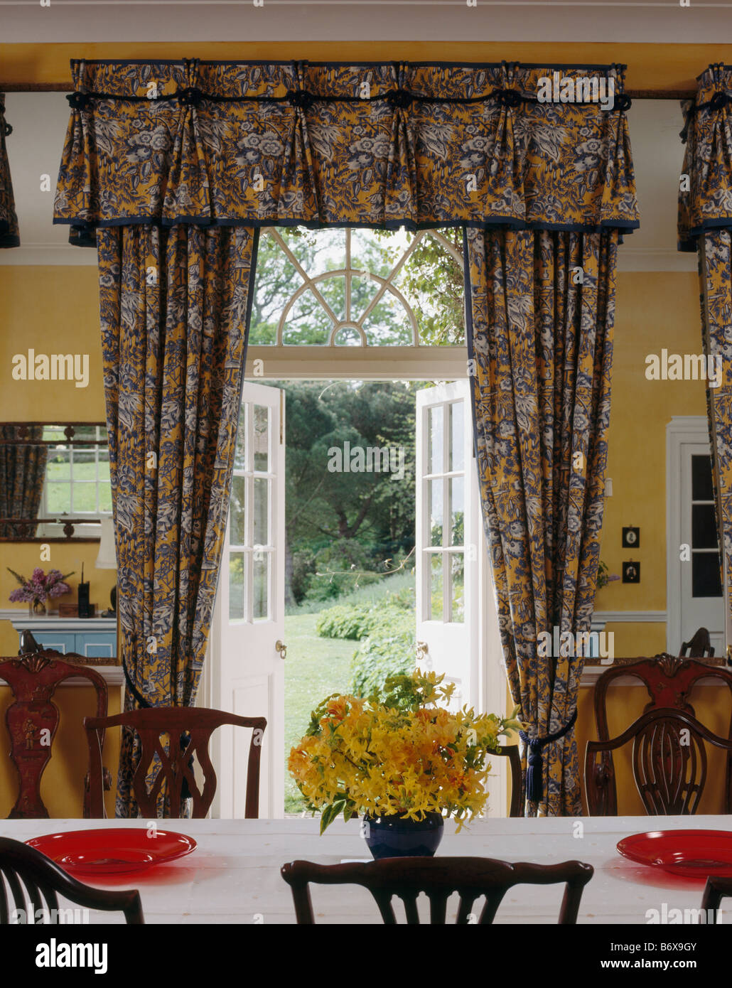 Patterned Curtains At Open French Doors With View Of Garden In