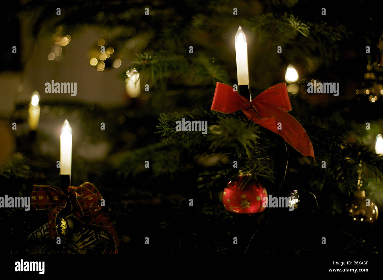 Christmas tree with electric candles, red bauble and bow Stock Photo