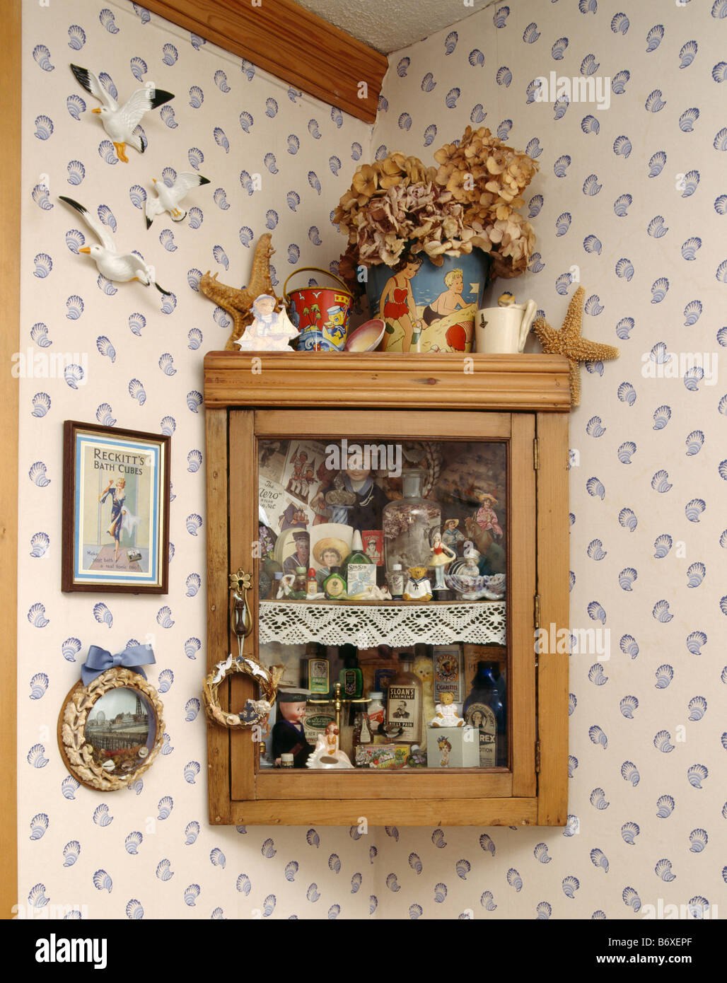 Close up of collection of children's thirties nautical toys and ornaments in glass fronted pine wall cupboard Stock Photo