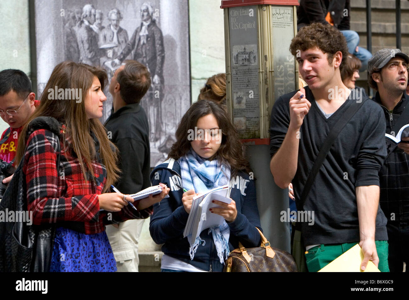 Students taking notes in front of the Federal Hall on 26 Wall Street in New York City New York USA Stock Photo