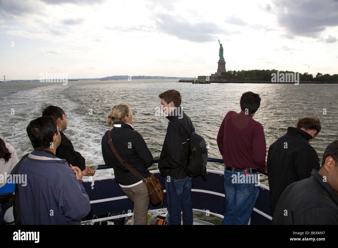 Tourists view the Statue of Liberty from a ferry boat in New York Harbor New York USA Stock Photo