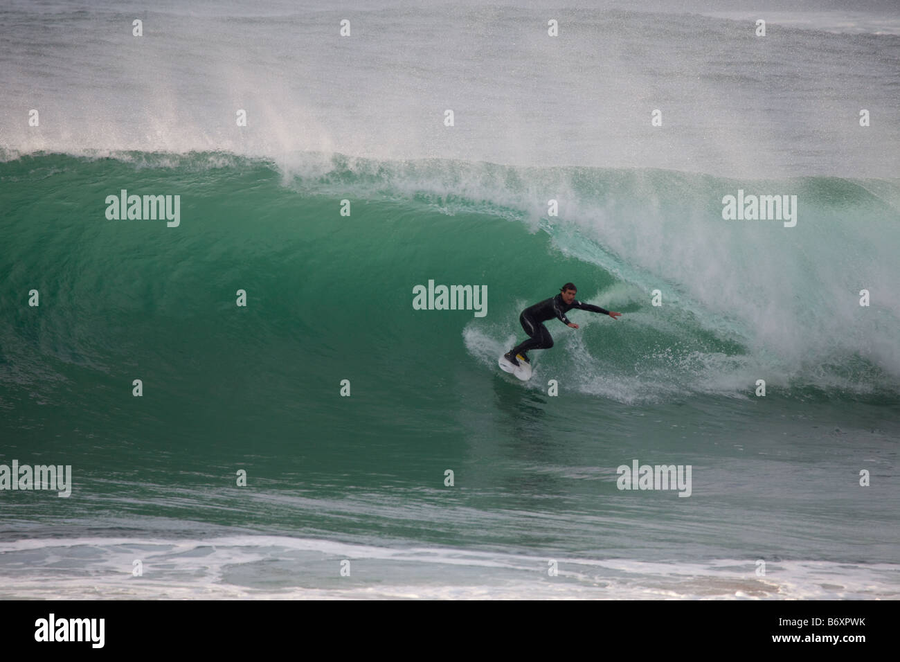 Surfer running away from a close out wave at Guincho Beach, Portugal Stock Photo