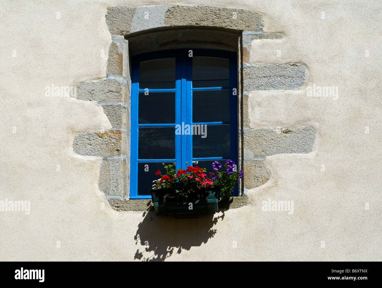 Traditional French windows with window box and flowers Stock Photo