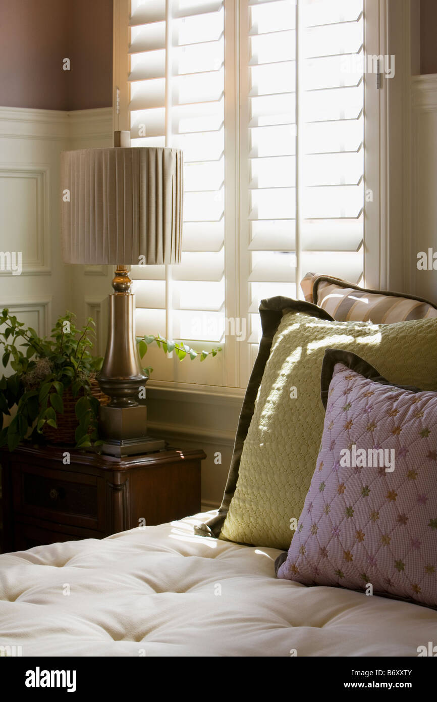 Purple and green decorative pillows on bed near window Stock Photo Alamy