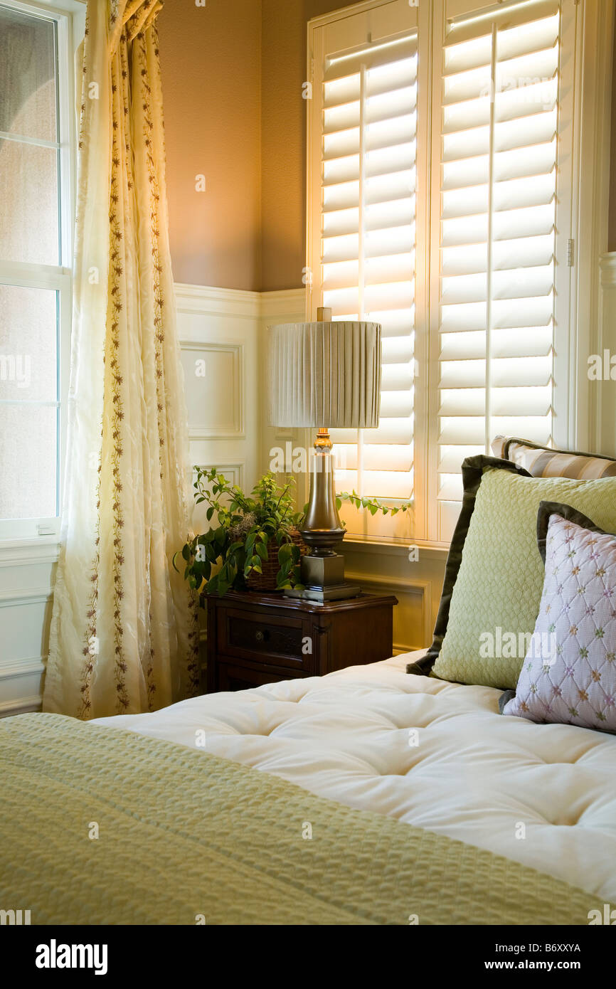 Purple and green decorative pillows on bed near window Stock Photo Alamy
