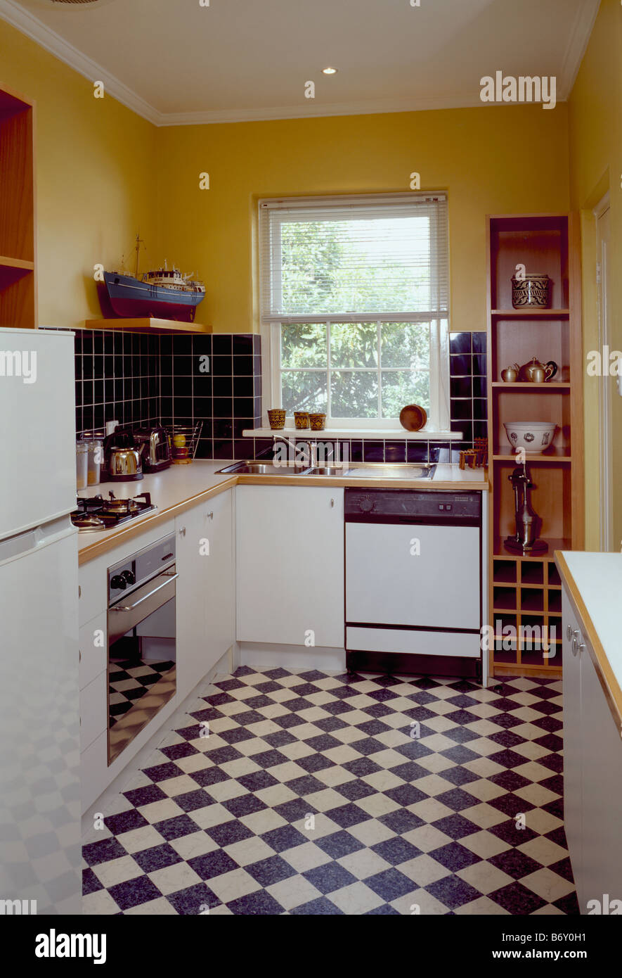 Black White Chequerboard Flooring In Yellow Kitchen With