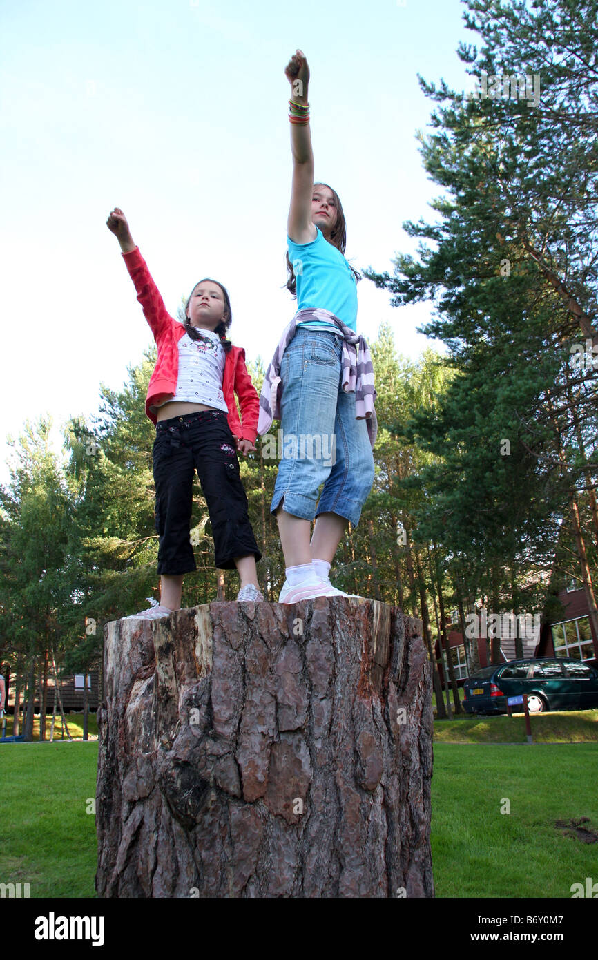 Two girls posing on old tree stump Stock Photo