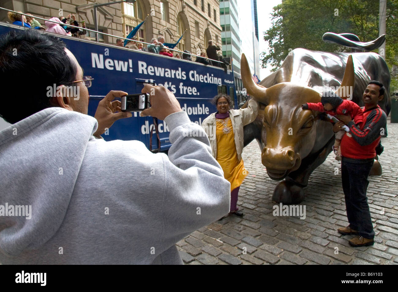 People having their photo taken with the Wall Street Bull in Bowling Green park near Wall Street New York City New York USA Stock Photo