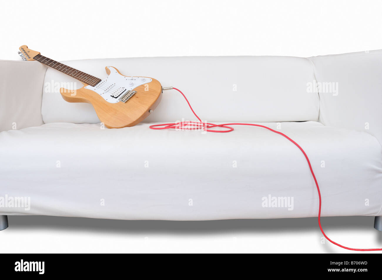 Guitar lazing on white couch (cut-out) Stock Photo