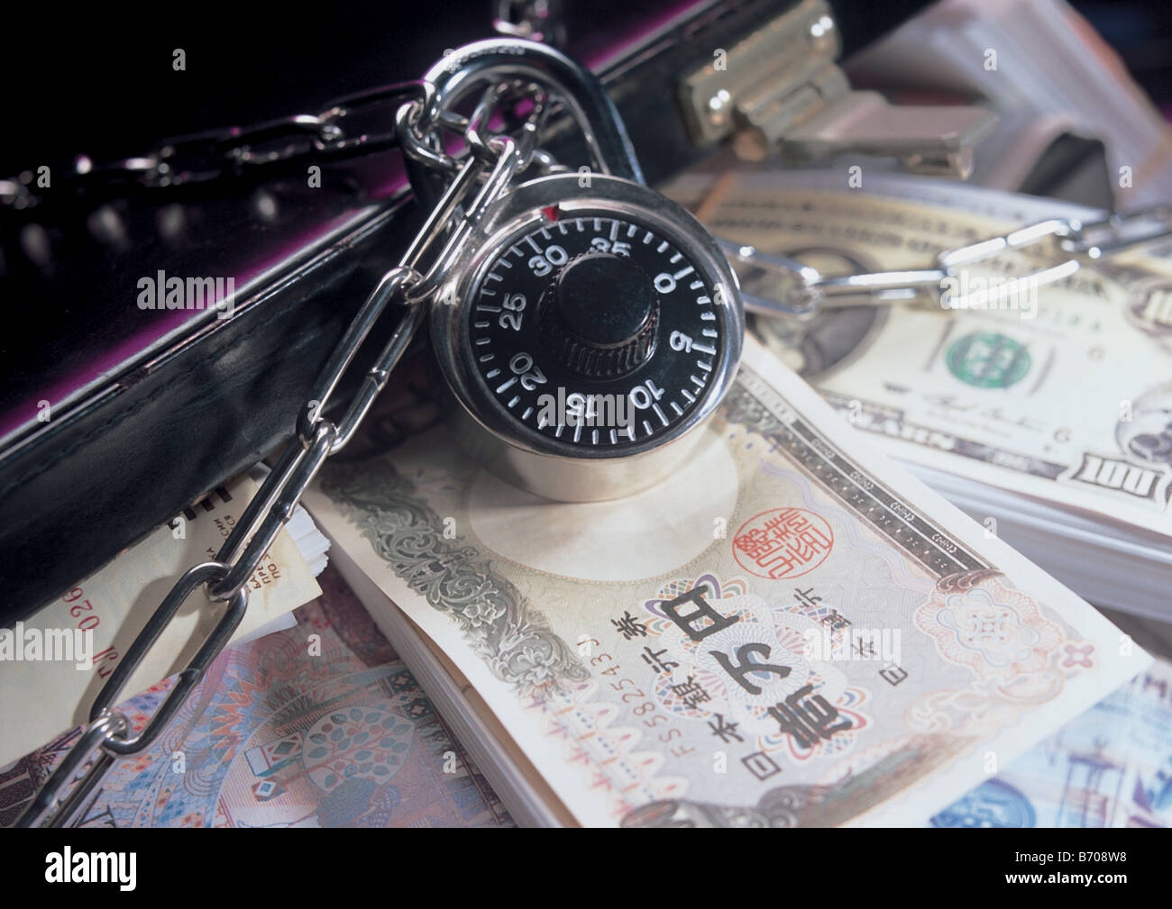 Piles of money and breifcase are locked up Stock Photo