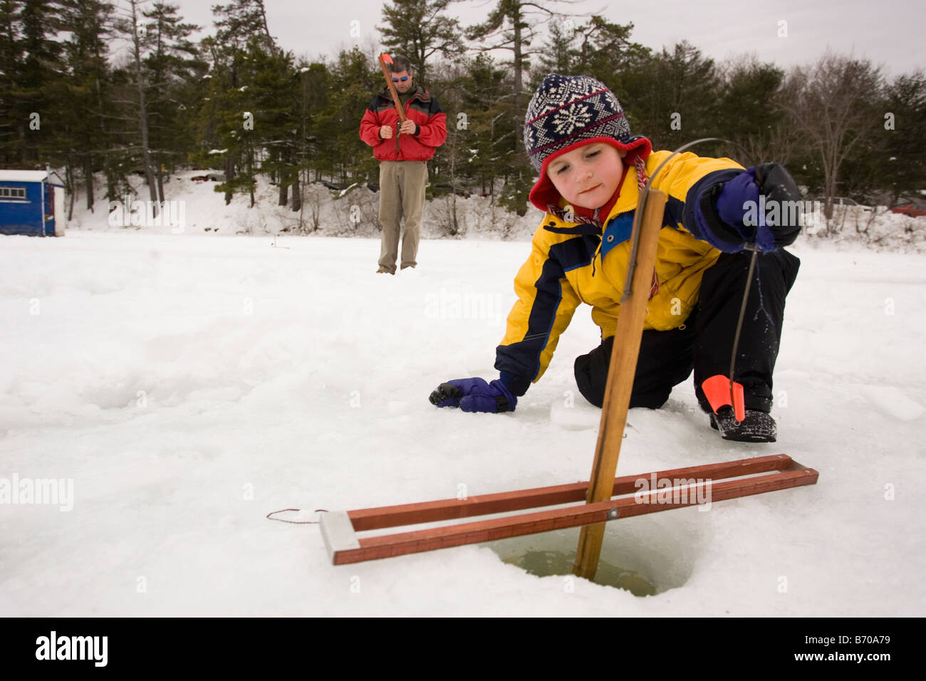 A boy checks traps, while ice fishing on Maine Lake in North Waterboro