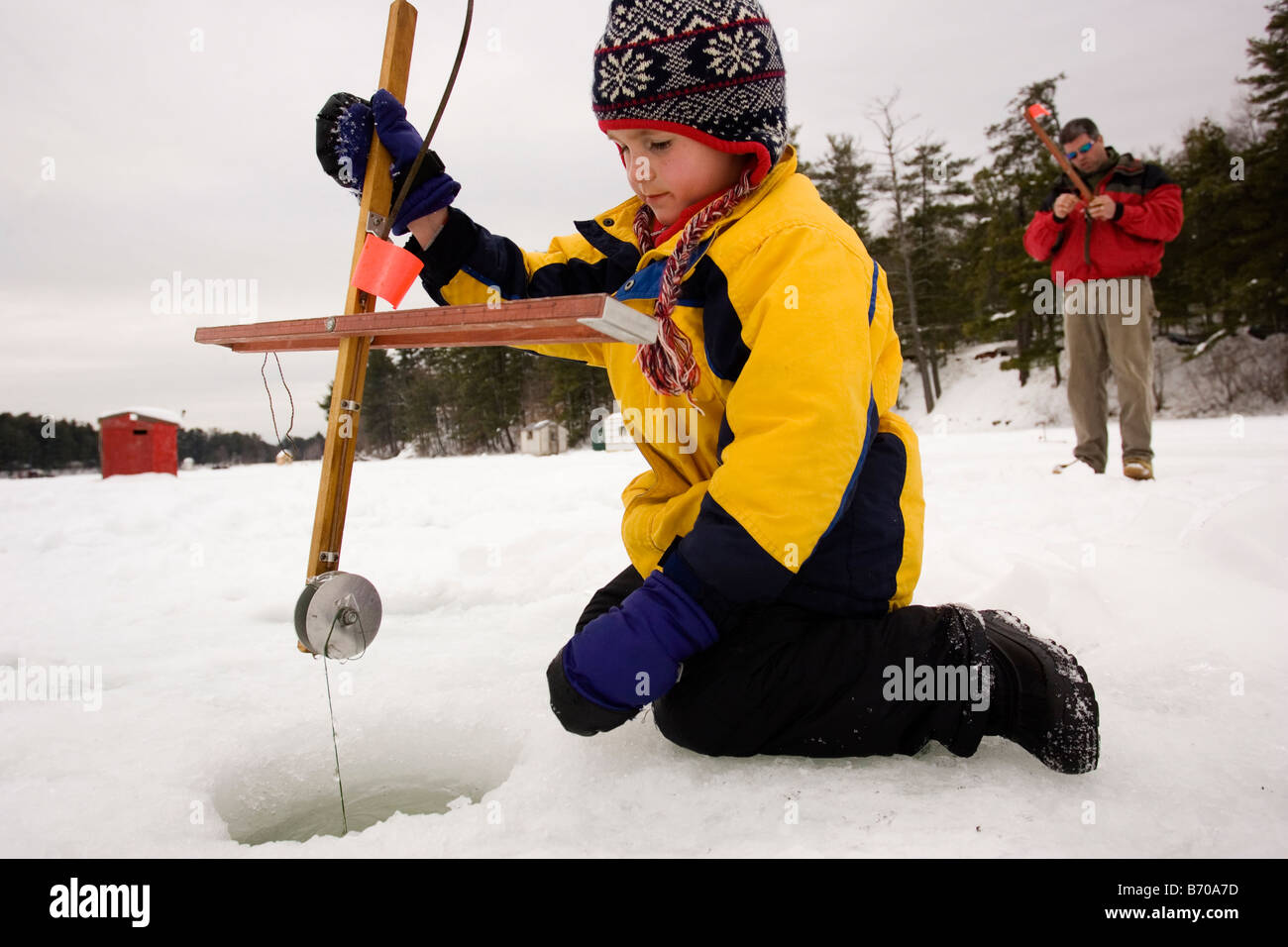 A boy checks traps, while ice fishing on Maine Lake in North Waterboro