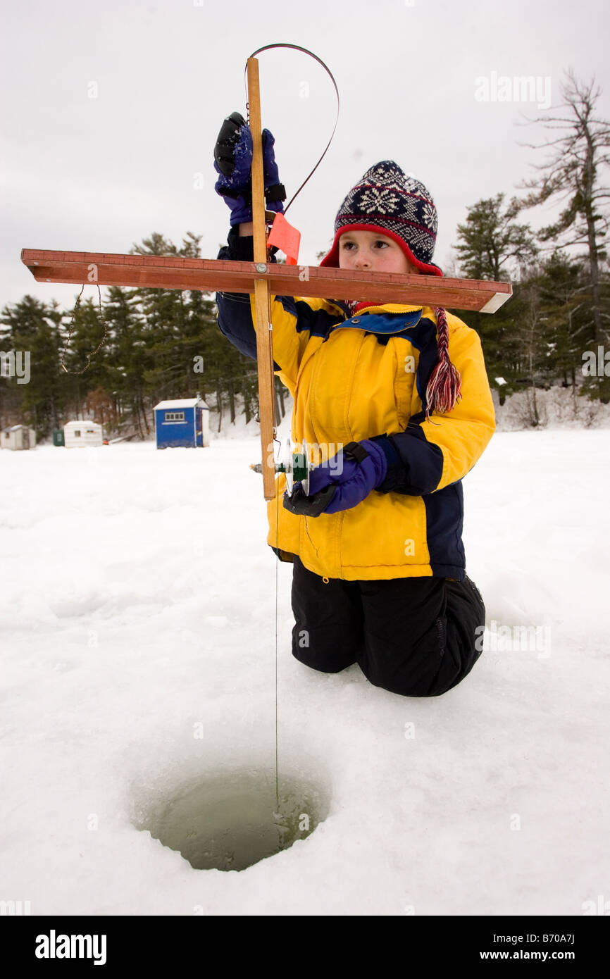 A boy checks traps, while ice fishing on Maine Lake in North Waterboro