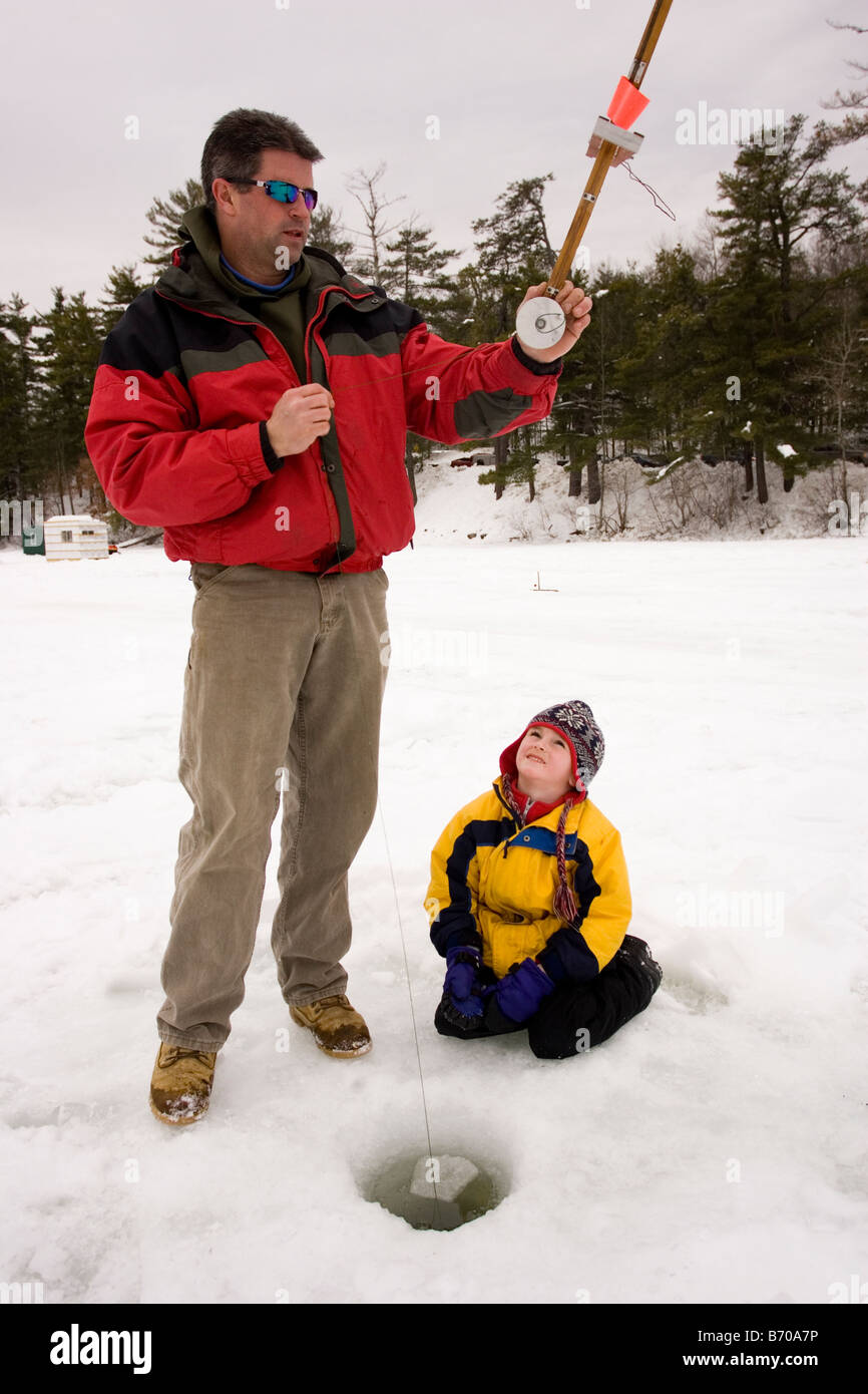 A man and a child check traps, while ice fishing on Maine Lake in North