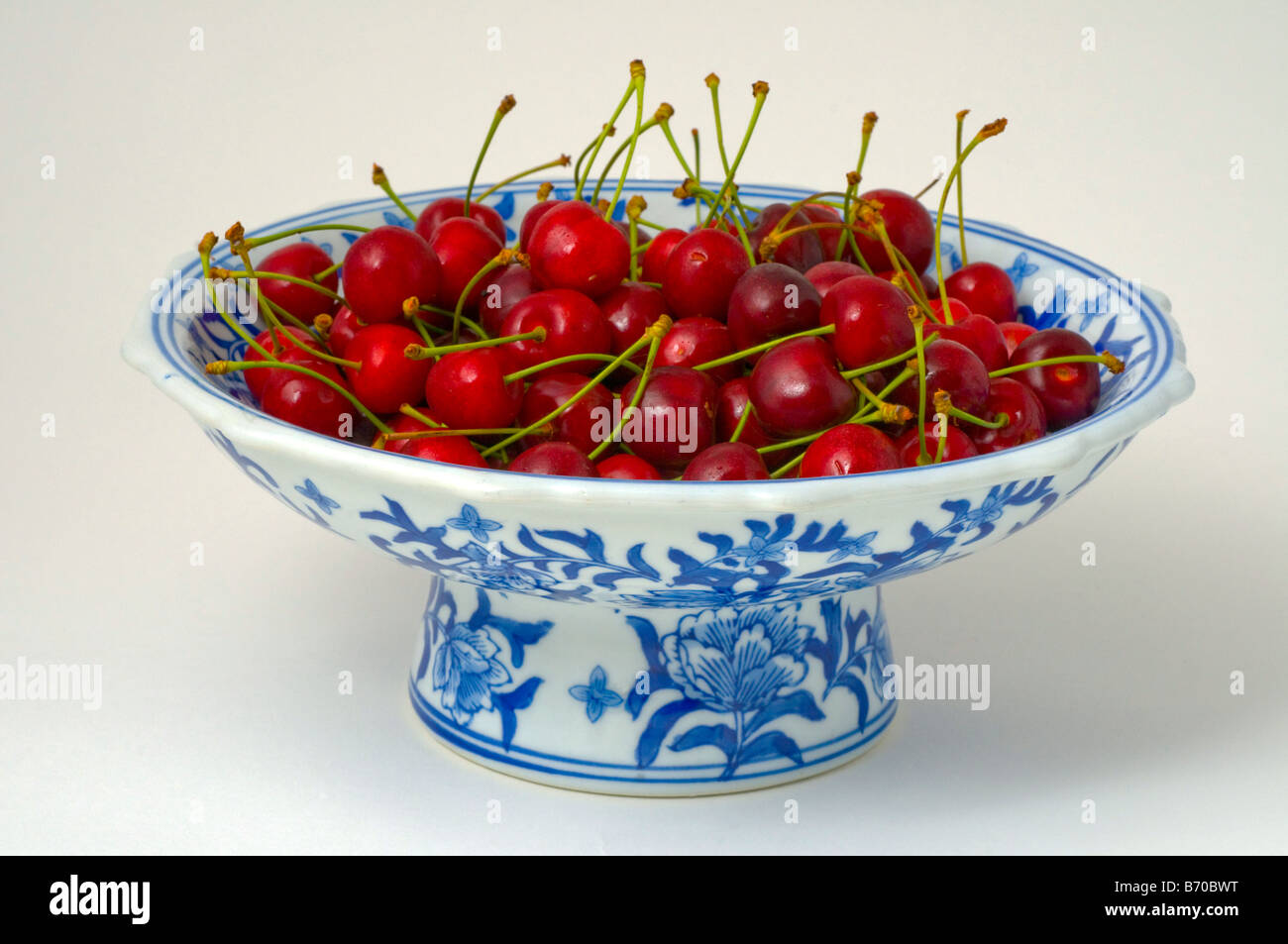 Ripe cherries in blue and white glazed bowl Stock Photo Alamy