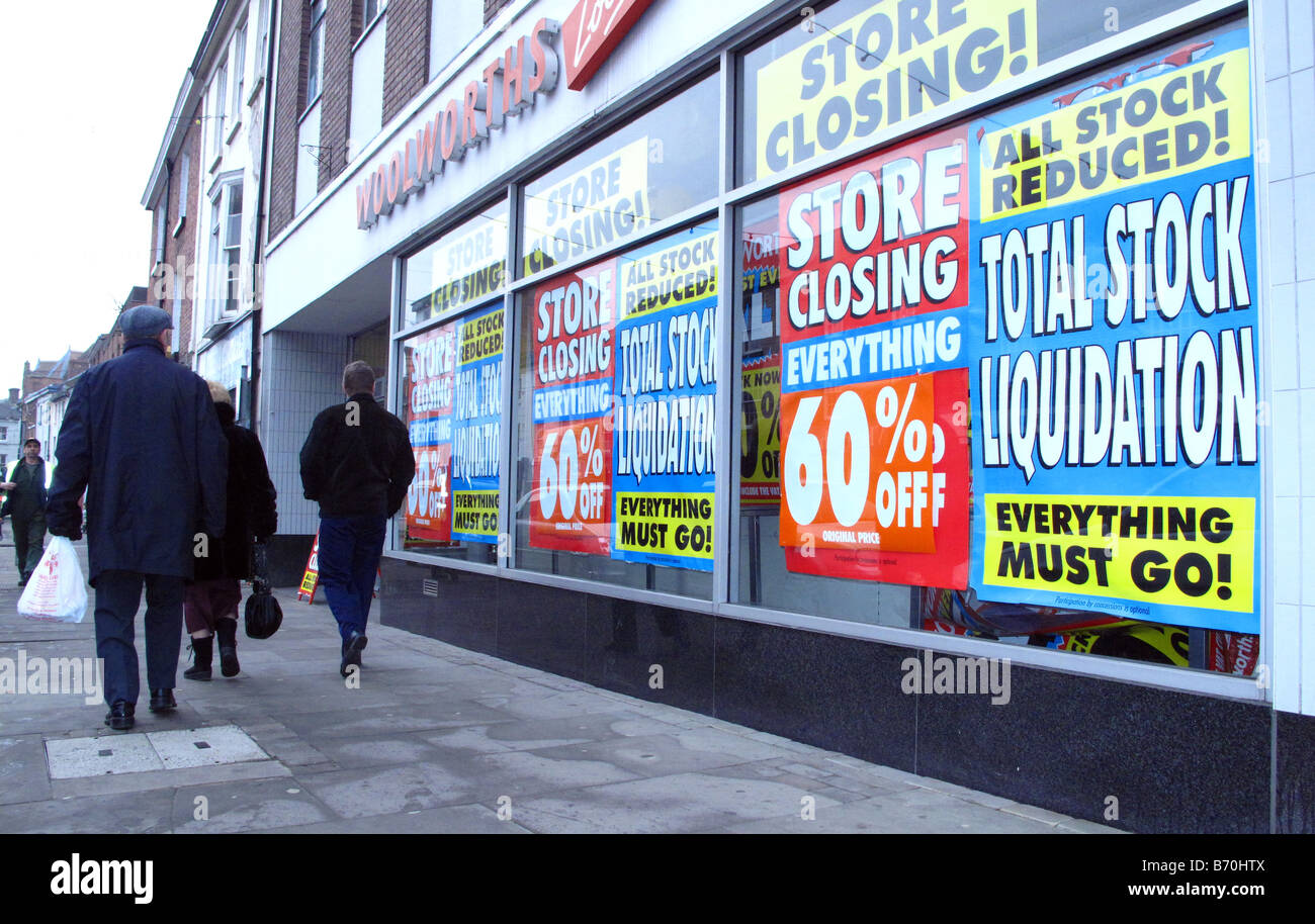 Shppers outside Woolworths store with windows full of liquidation sale signs after bankrupsy before closing down in recession Stock Photo