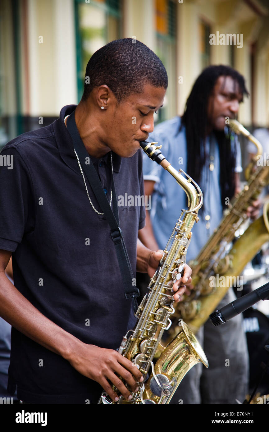 Man playing saxophone and busking at a street concert in Port Louis