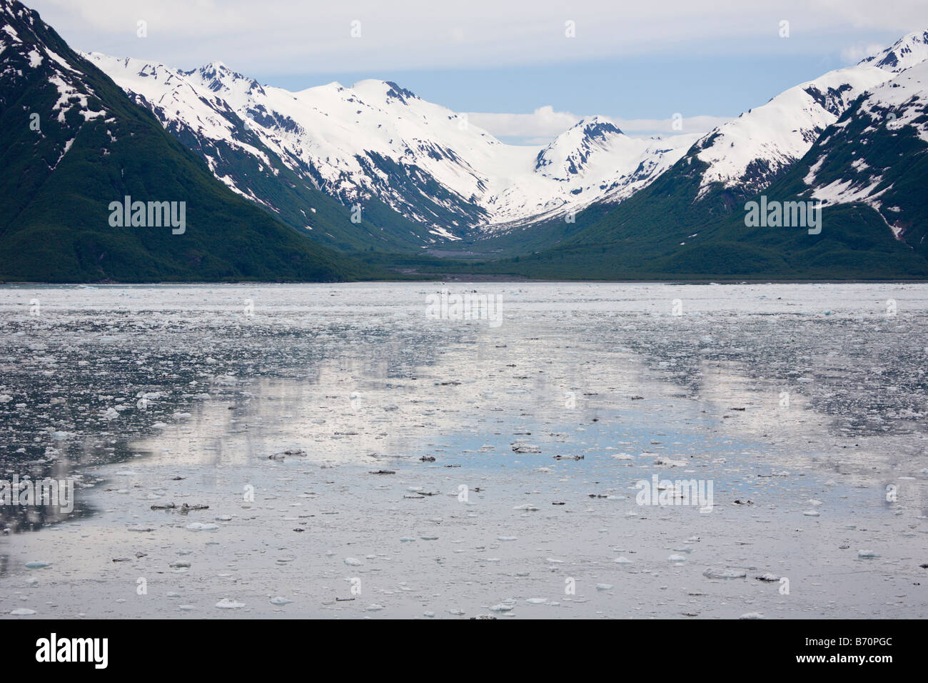 Ice from Hubbard Glacier flows past snow covered mountains into Disenchantment Bay and Yakutat Bay in Alaska Stock Photo