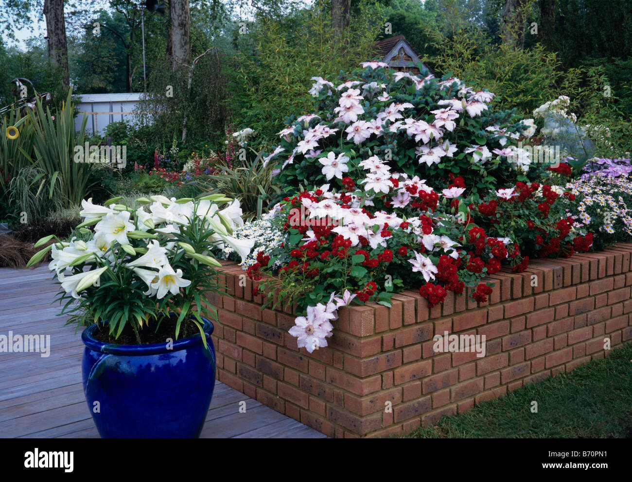 A raised garden border with blue flower container Stock Photo
