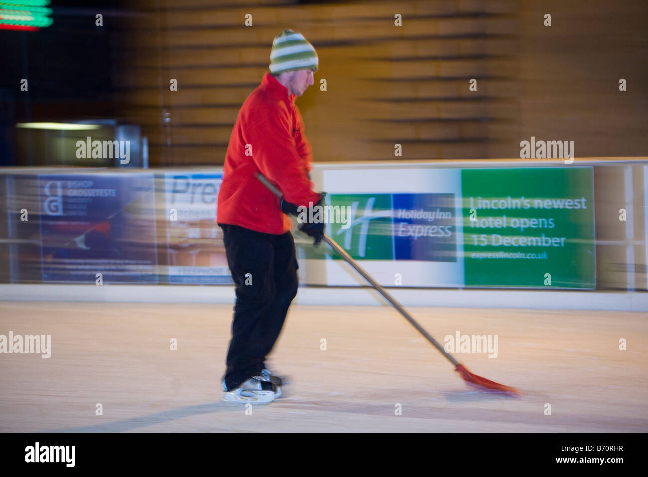 A member of Staff prepares the ice for skaters on an artificial ice rink in Lincoln city centre UK Stock Photo